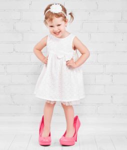 Little girl in oversize high heels